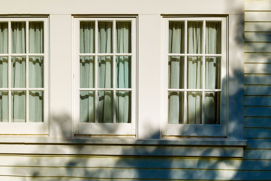 Stylish facade featuring classic French windows with soft shadows and light play.